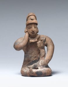 Larger ceramic figure sits cross-legged, one hand resting at its neck, the other on a small child in its lap.