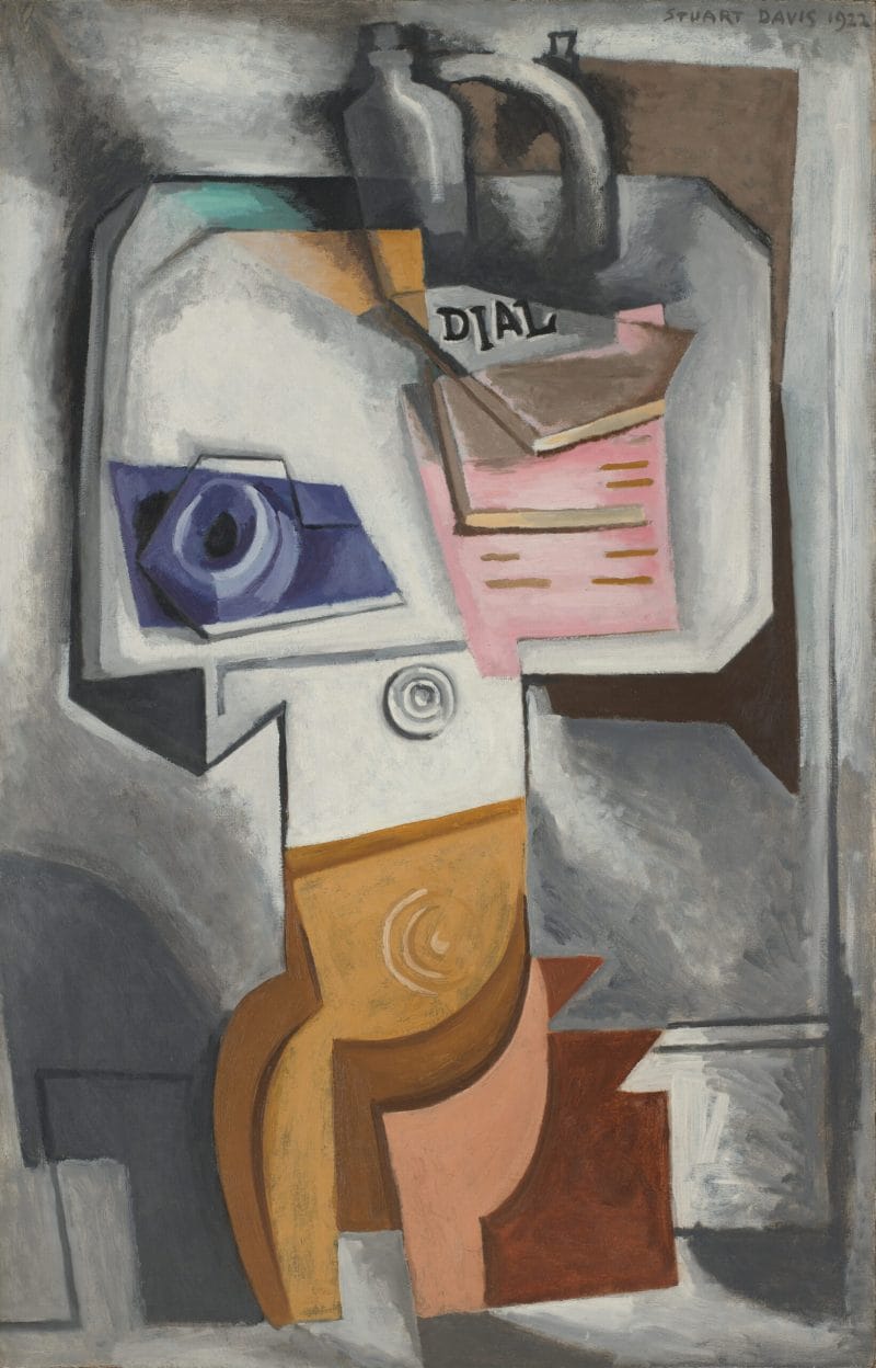 A cubist still life featuring a cup and saucer, stack of magazines, and jug on an upturned table top.