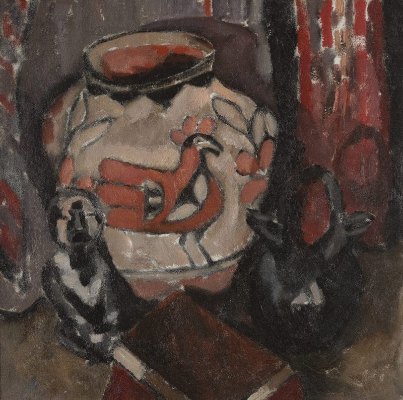 A still life painting featuring an Acoma pot decorated with a bird and leaf designs, a Santa Clara double-spouted jug, a small figure sculpture and a book on a table in front of a red tapestry.