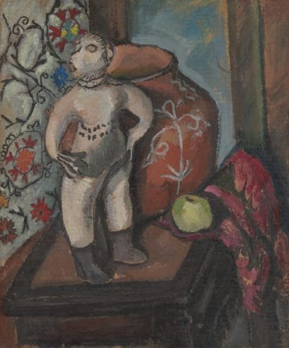Still life painting featuring a Cochiti Mono figure, a red pot with white detailing, a green apple, and pink fabric on an upturned tabletop in front of a multicolored tapestry.