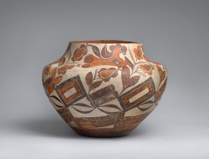 An Acoma jar decorated with birds, flora, and geometric shapes.