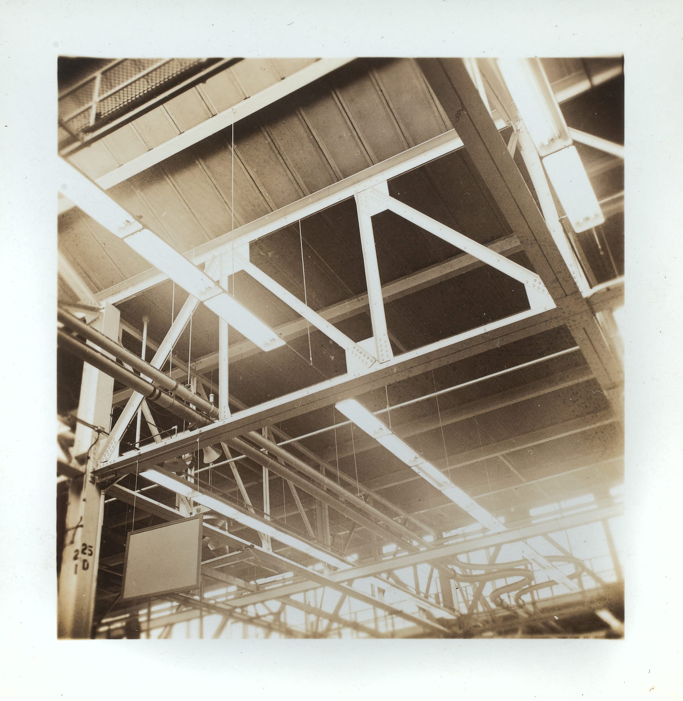 Sepia photograph of the ceiling fixtures in an aircraft plant.