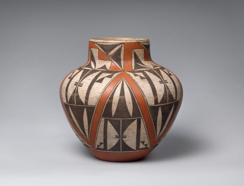 Rust-orange Acoma pot with a black and white geometric design.