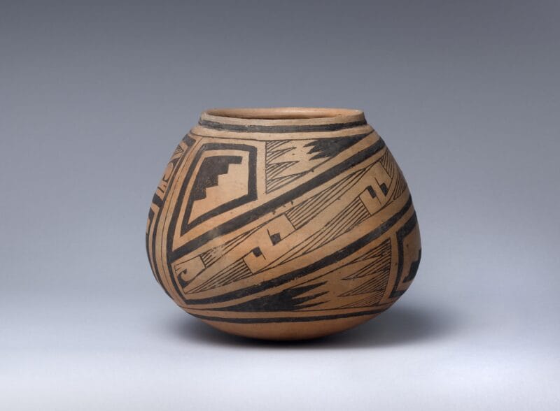 Clay bowl with black geometric design on exterior.