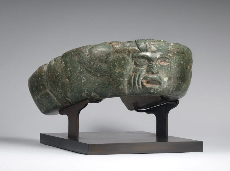 Dark green yoke effigy carved with a human face.
