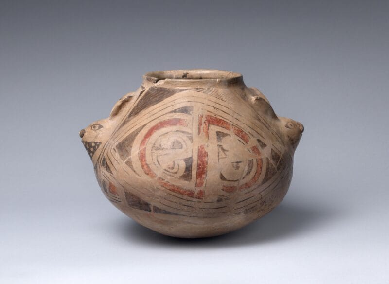 Decorative ceramic bowl covered with complex, interlocking geometrical designs with two abstract rabbit heads on either side.