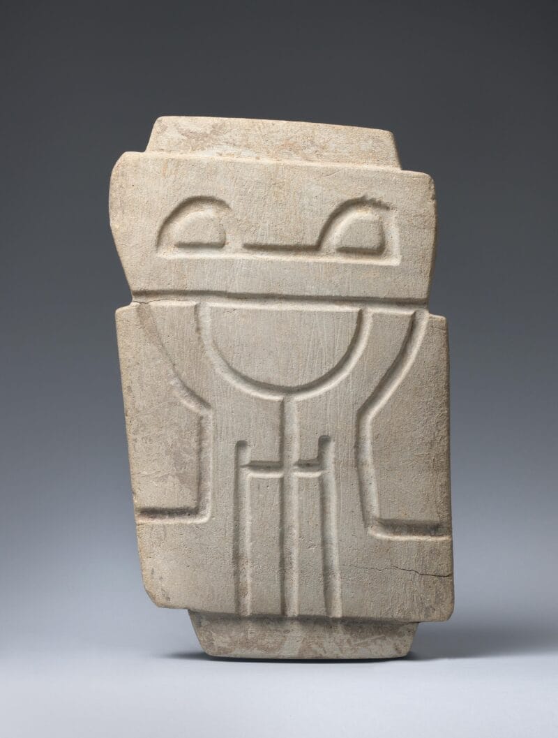 Stylized human figure carved into grey-green stone.