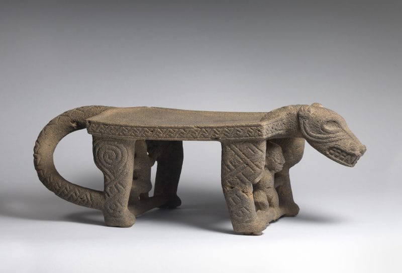 Stone metate carved in the shape of a jaguar with monkeys between its legs.