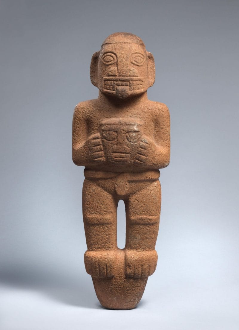 Ceramic standing figure with exposed teeth, tongue out, and snake wrapped around its waist, holding a head.