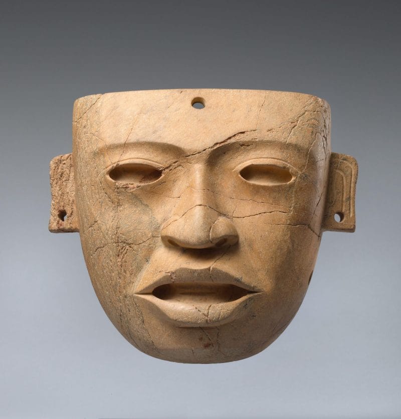 Light brown realistic face mask with hollowed eyes, open mouth, and pierced ears.