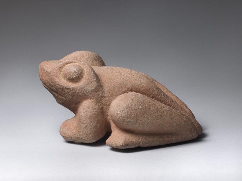 Stone sculpture of a perched frog.