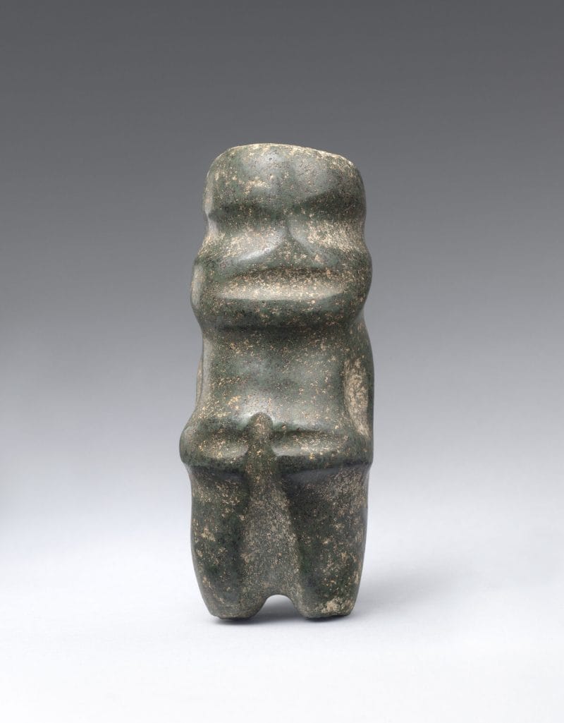 Abstract standing figure with rounded features, carved from stone.