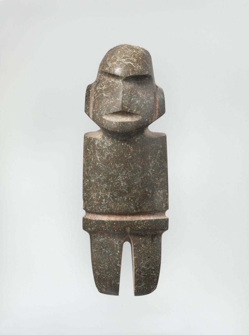 Abstract standing figure with no arms and indented features to represent facial features.
