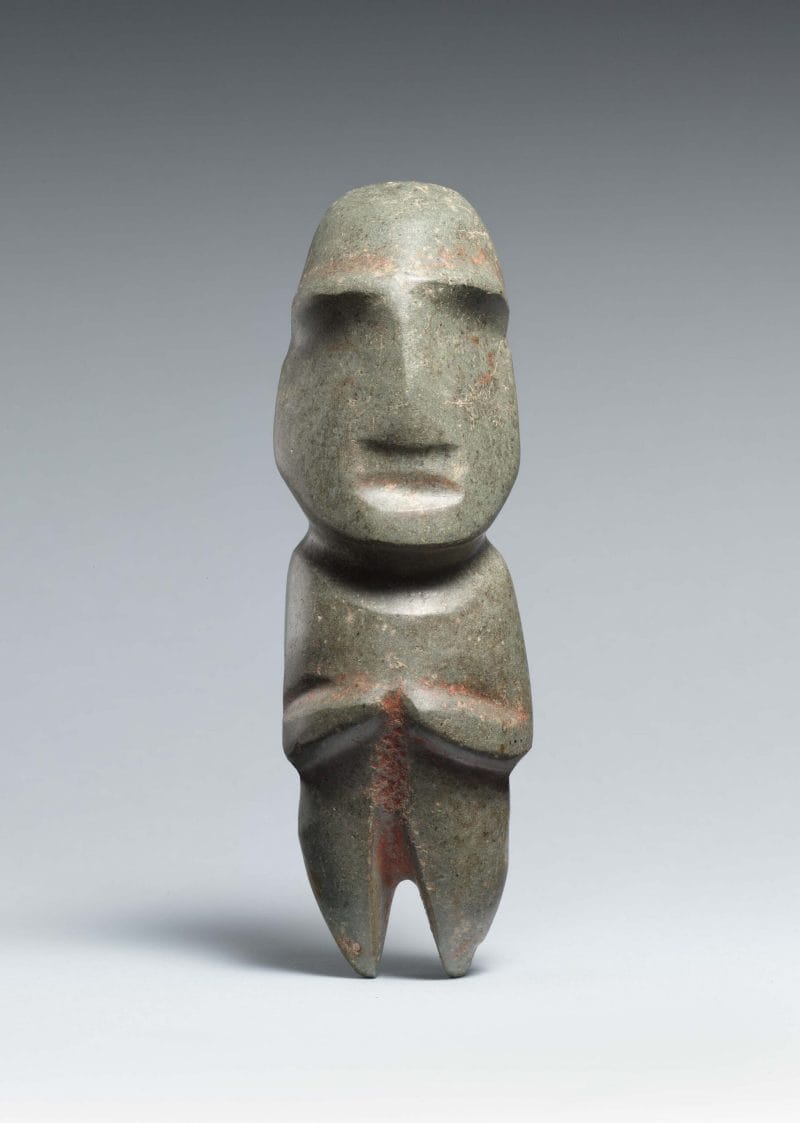 Abtract figure with arms crossed in front and a rounded head with T-shaped nasal and eyebrow ridges.