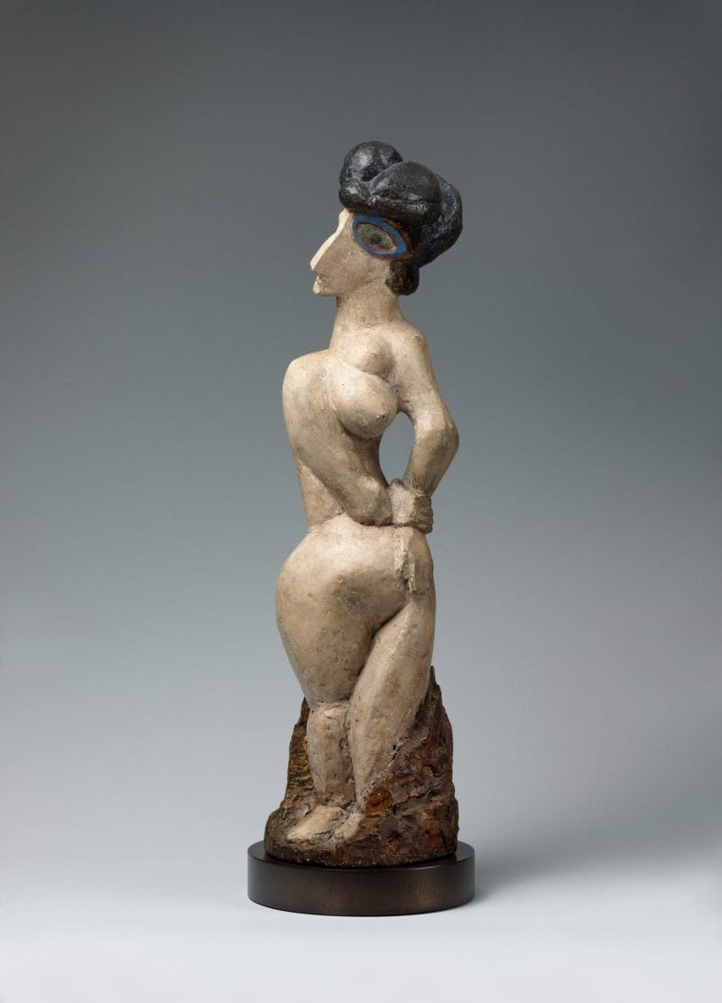 A sculpture of a nude woman with a disproportionately large green-blue eye twisting in space.