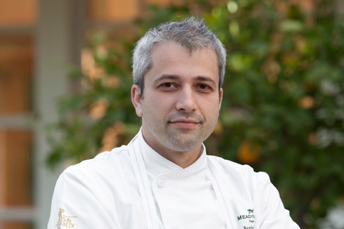 A photo of Boris Portnoy in a chef's jacket outdoors.