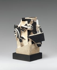 Tan sculpture made of smaller black and white fragmented pieces extending from the base.