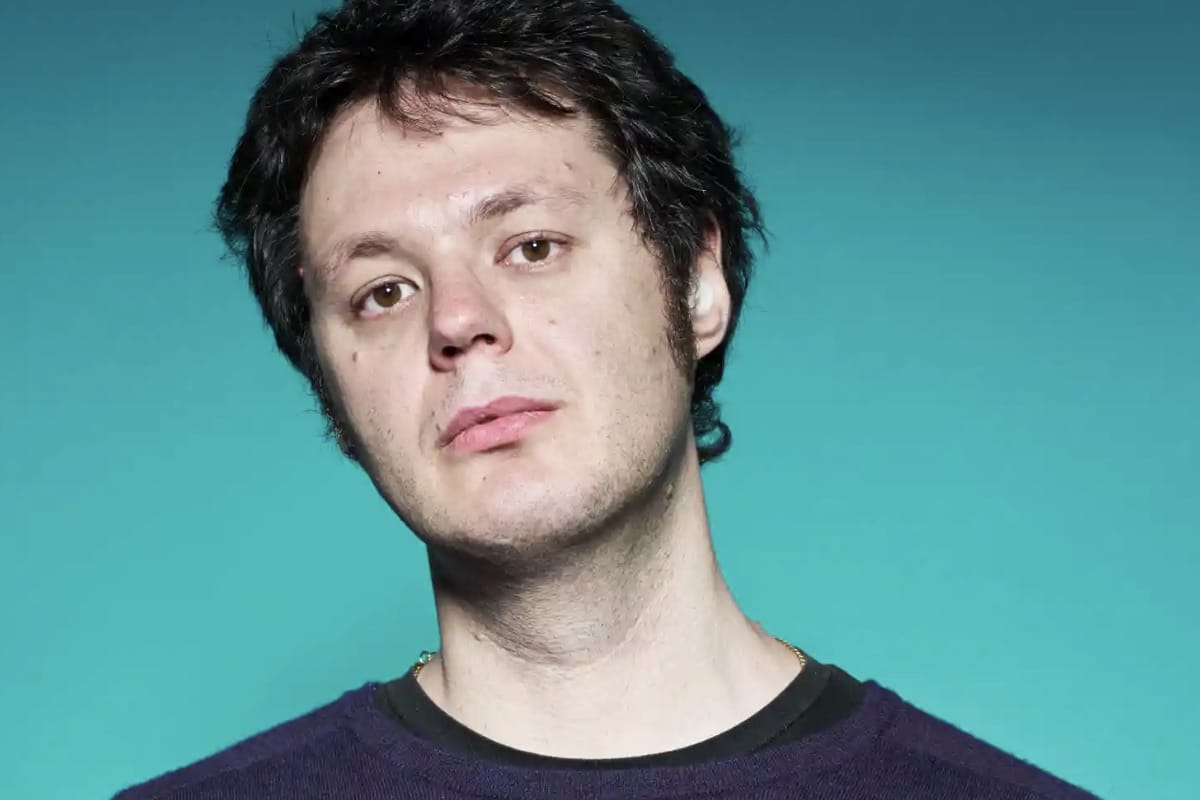 A photo of Ilya Kaminsky against a green background.