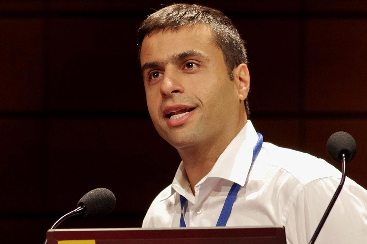 A photo of Hashim Al-Hashimi at a podium giving a lecture.