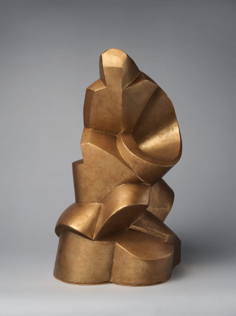 Gold sculpture of broad, cylindrical and flat-edged forms including a spiral.