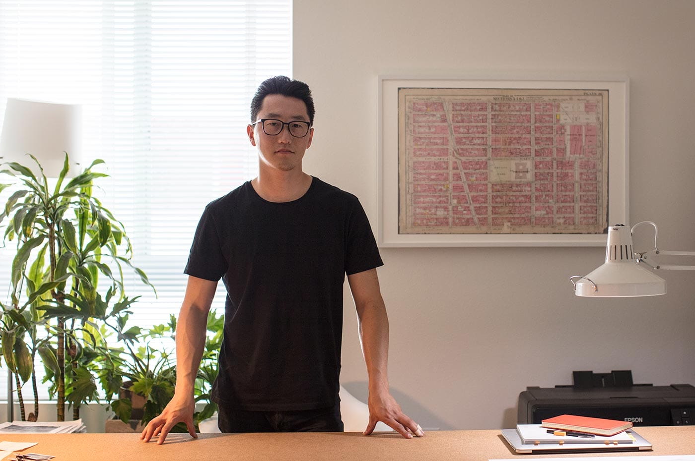 James Leng standing behind his desk.