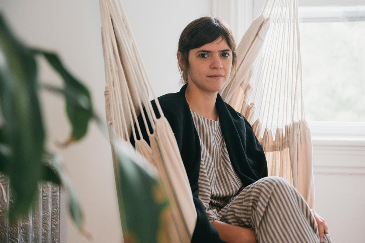 Vilcek Prize for Creative Promise winner Valeria Luiselli sitting on a hanging chair in her home in New York.