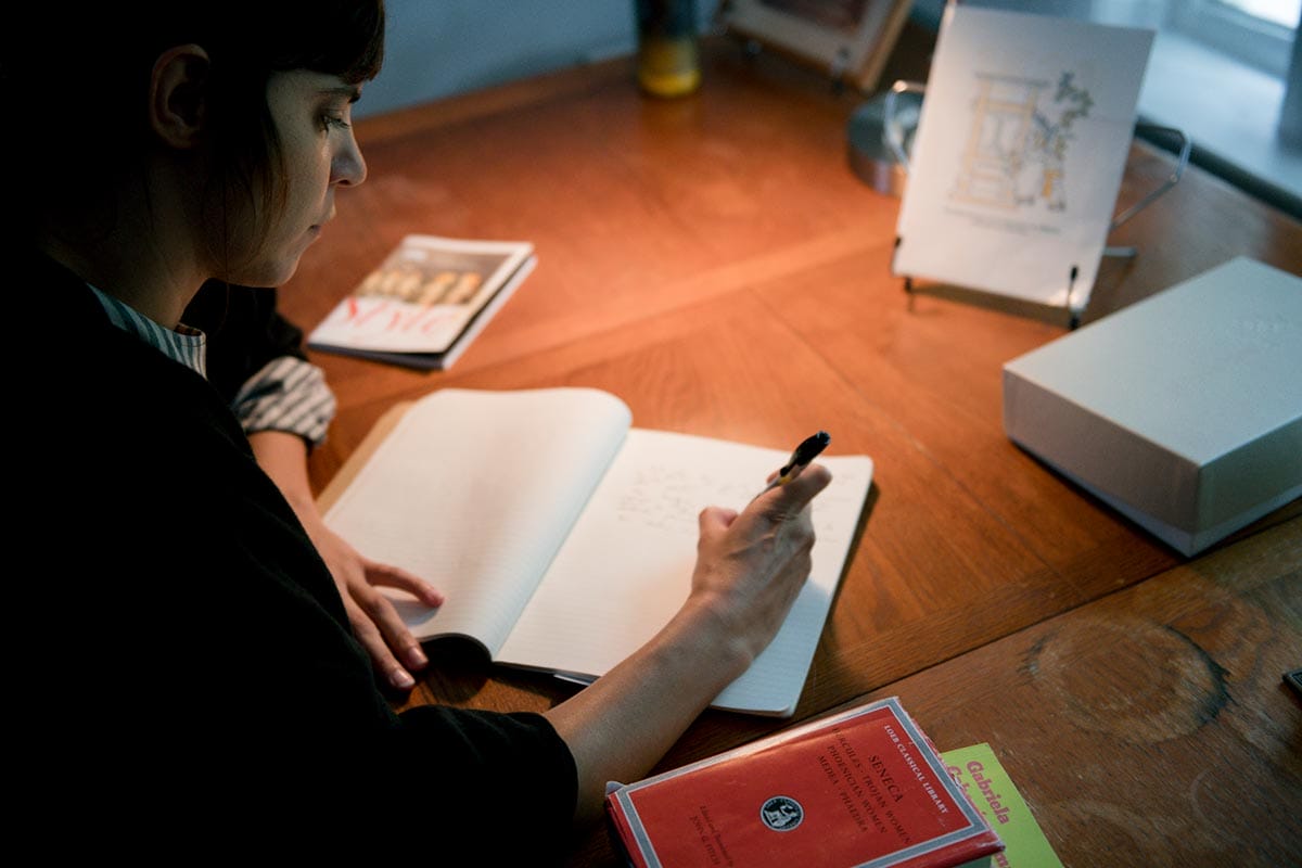 Valeria Luiselli writing in a journal.