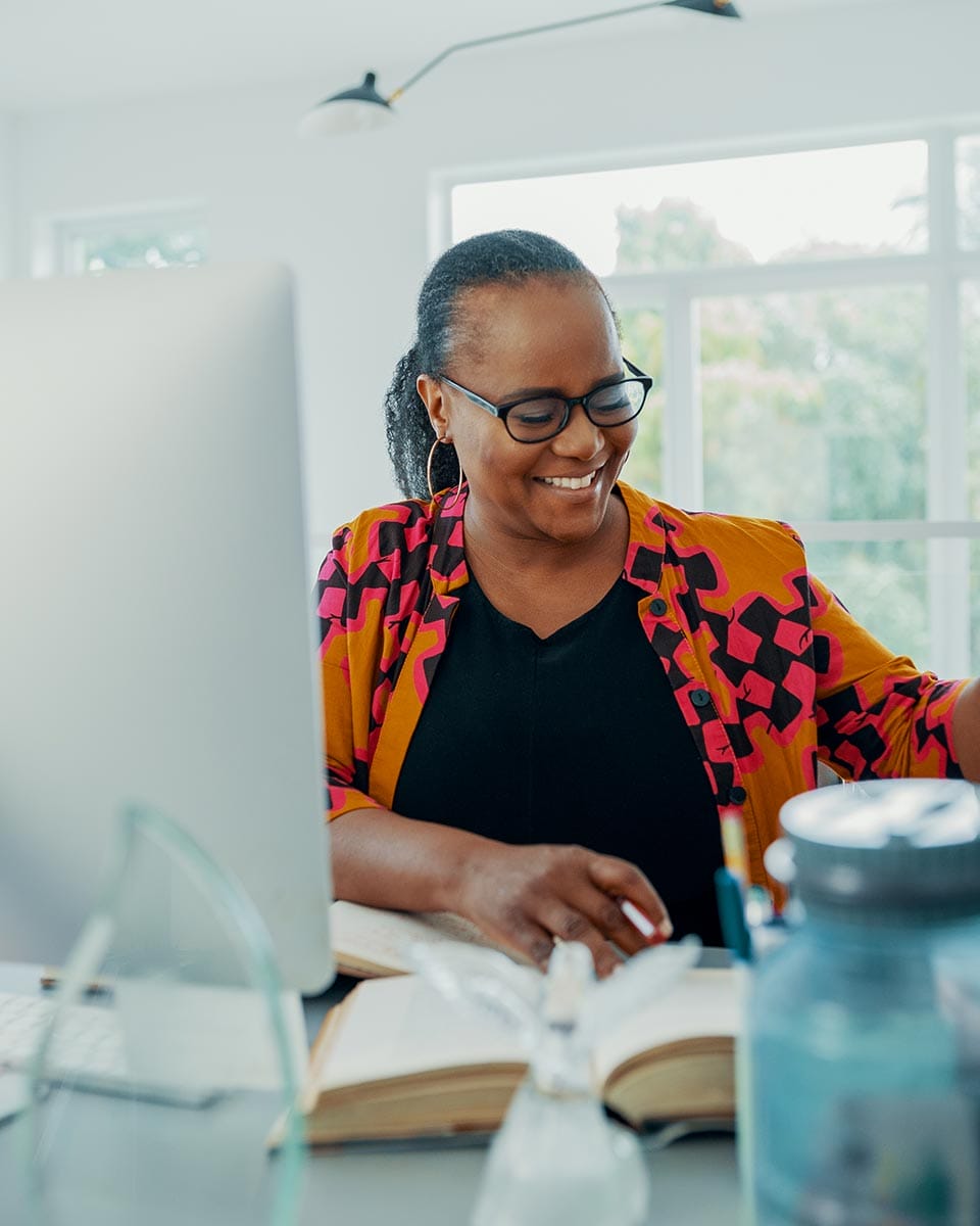 A photo of Edwidge Danticat writing at a computer.