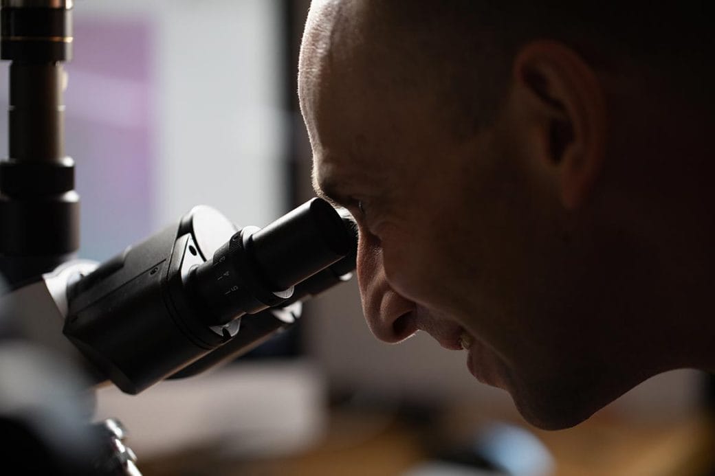 Martin Jonikas looking through a microscope.