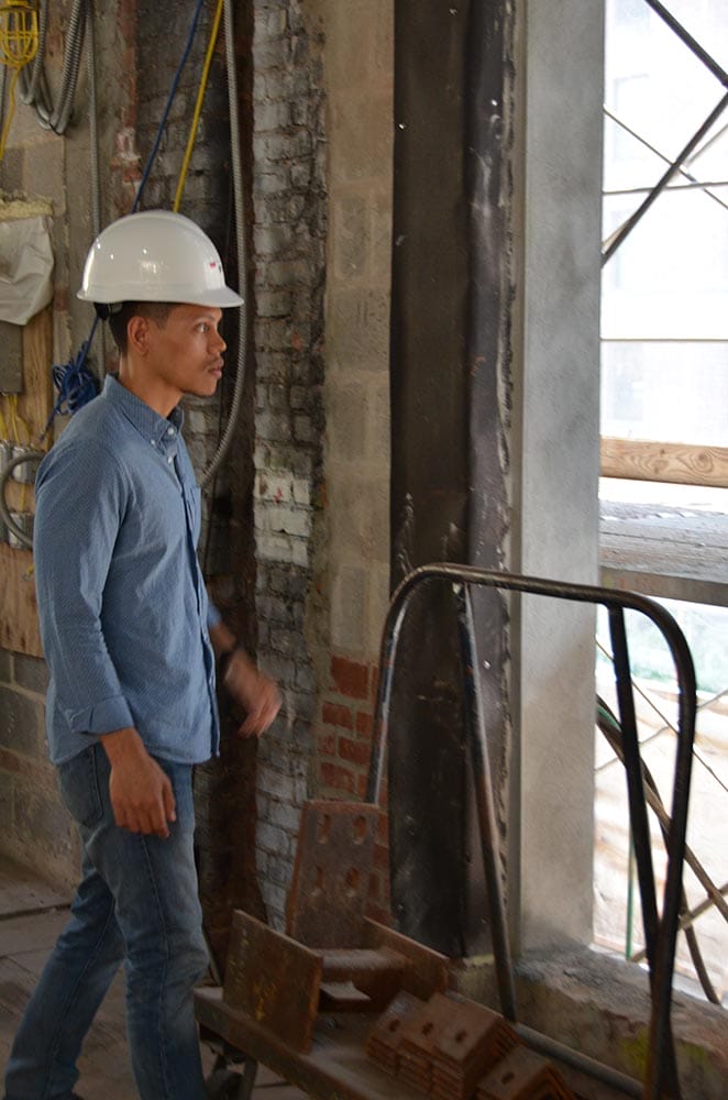 Ronnie Mewengkang, wearing a hard hat, surveying construction and window at the foundation's new headquarters.