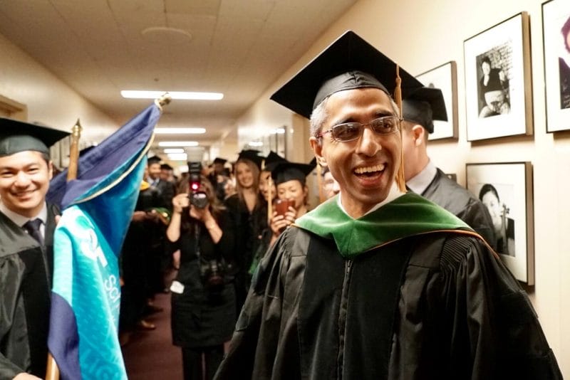 Vivek Murthy smiles while dressed in his graduation cap and gown.