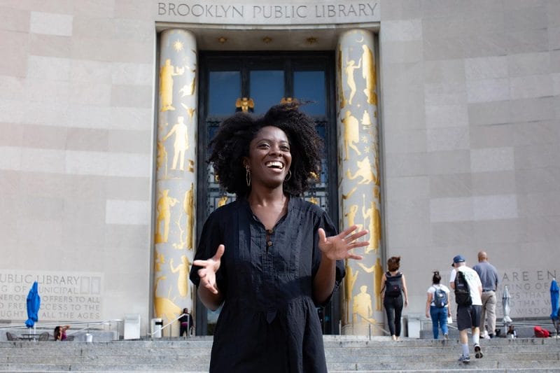 Yaa Gyasi standing on the steps of Brooklyn Public Library