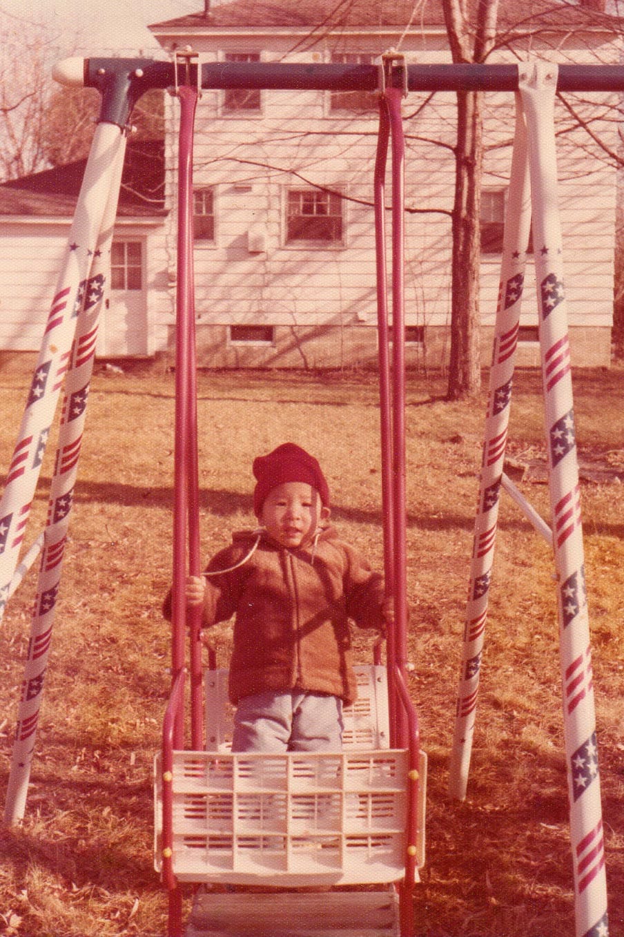 Andrew Yang, at age 2, sitting on a swing set in his home of upstate New York.