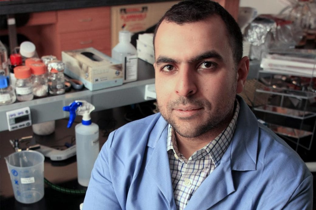 Mohamed Abou Donia, donning a lab coat, in his science lab.