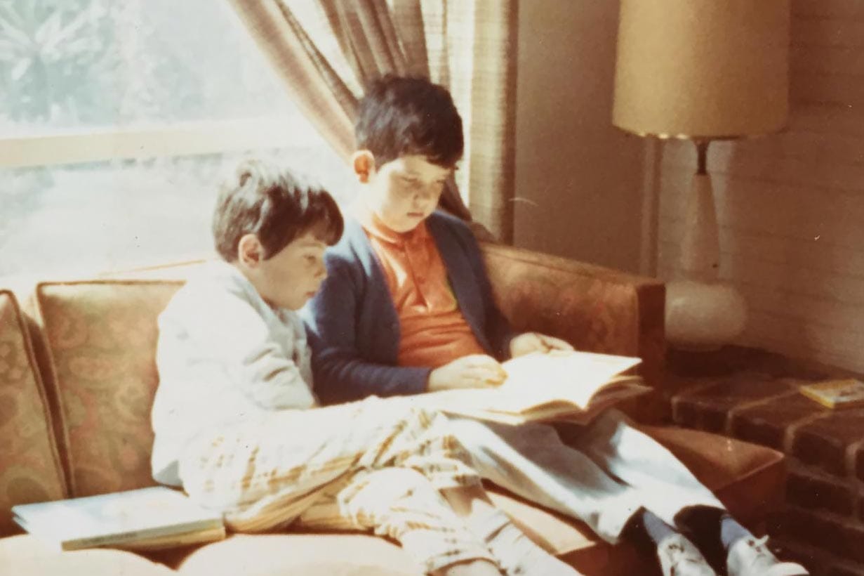 Rodrigo Prieto, as a child, sitting on a couch with his brother reading a book.