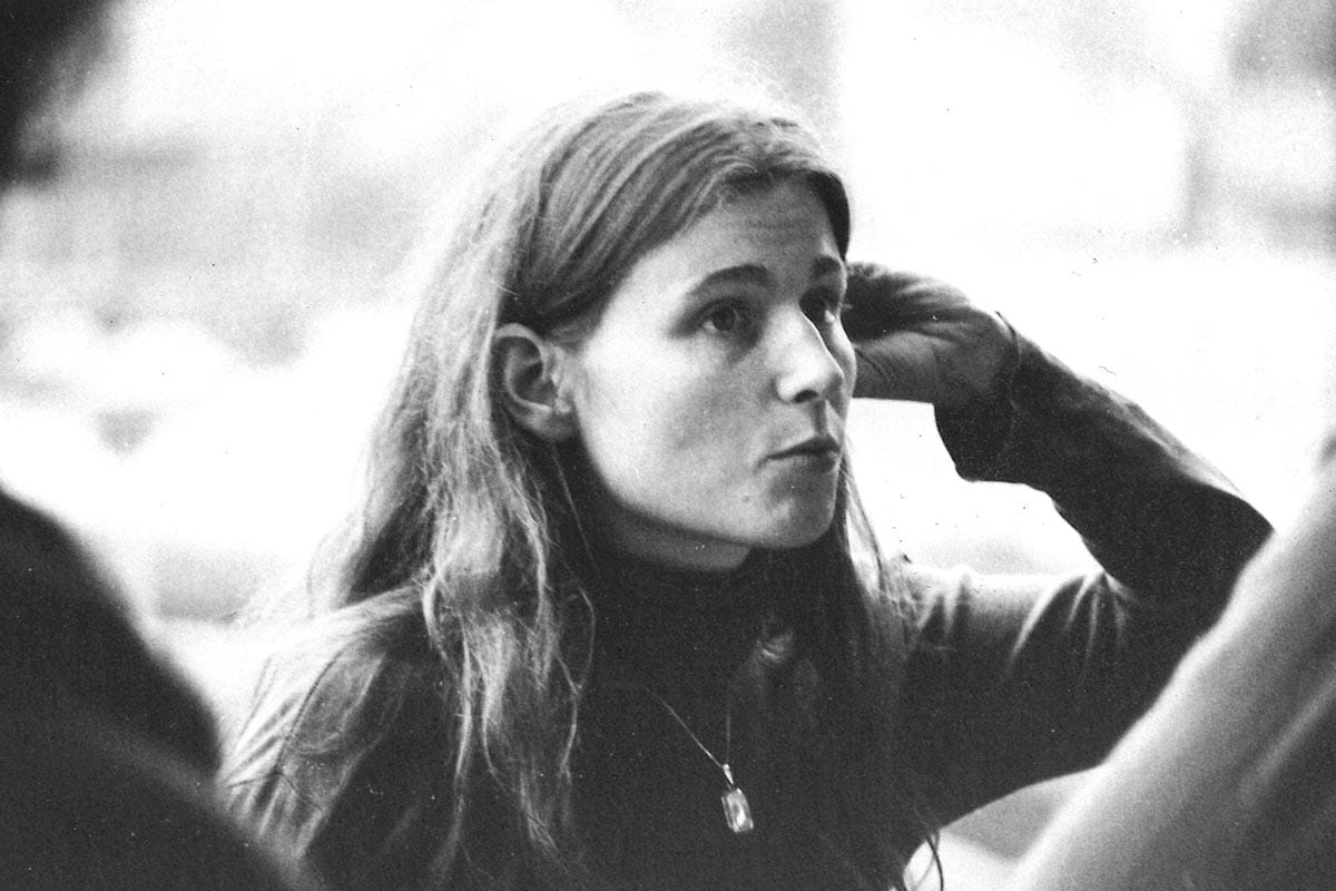 A black and white photo of Ruth Lehmann looking off screen during a conference.