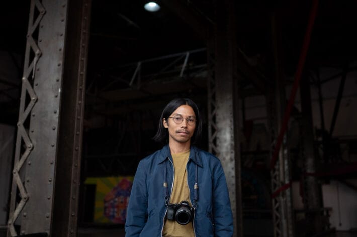 Miko Revereza framed by large, iron pillars.