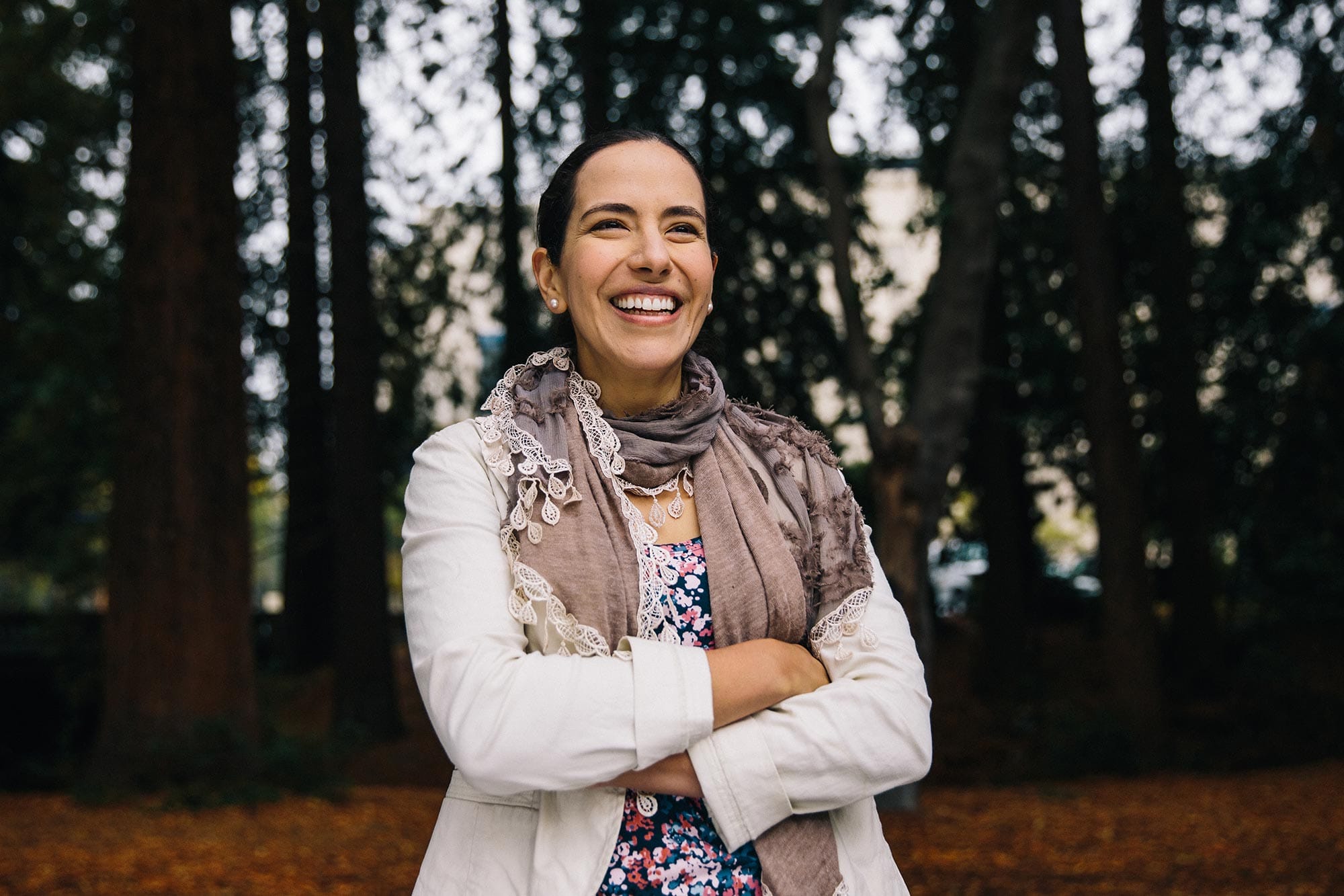 Markita del Carpio Landry smiling, arms folder, in front of a grove of trees.