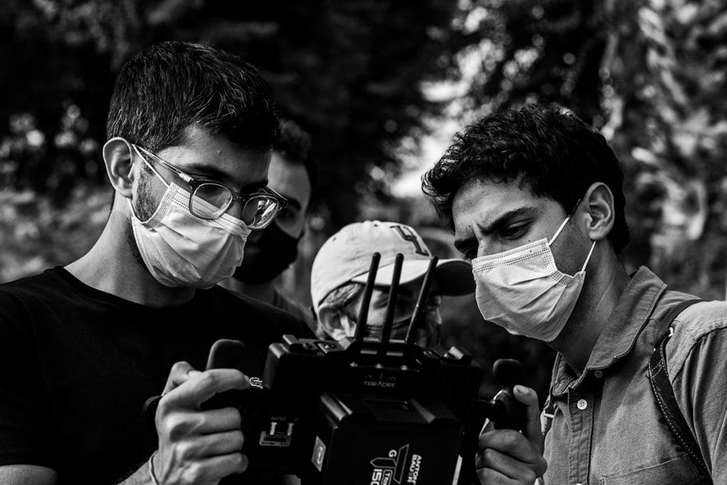 Filmmakers Roshan Sethi and Karan Soni looking into a viewing monitor while filming 7 Days.