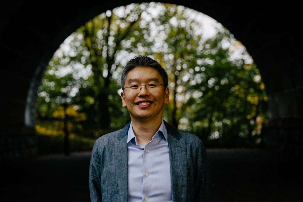 Harris Wang standing under a bridge smiling.