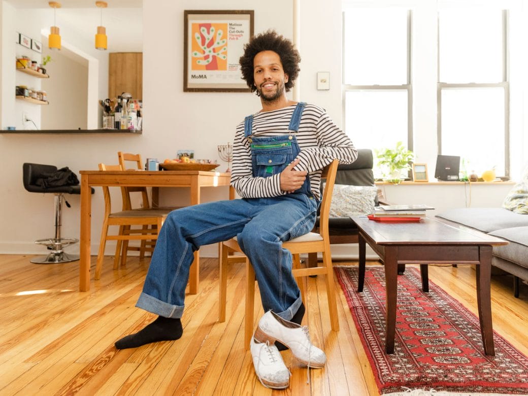 Leonardo Sandoval sitting inside with his tap shoes on the floor next to him.