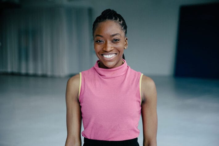 Headshot of Tamisha Guy smiling in a pink shirt.