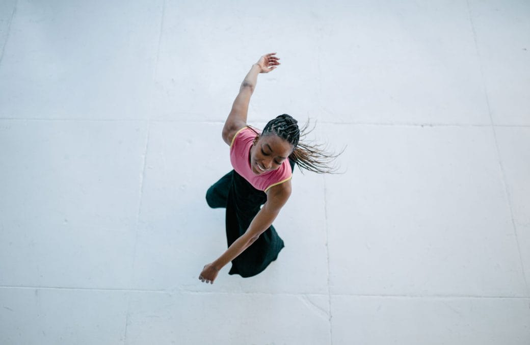 Aerial shot of Tamisha Guy dancing in a pink shirt.