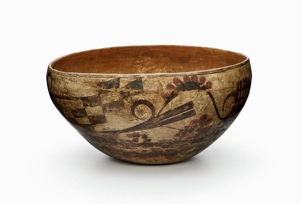 A four-color Acoma dough bowl featuring a white slip with black, red, and orange painted decoration.