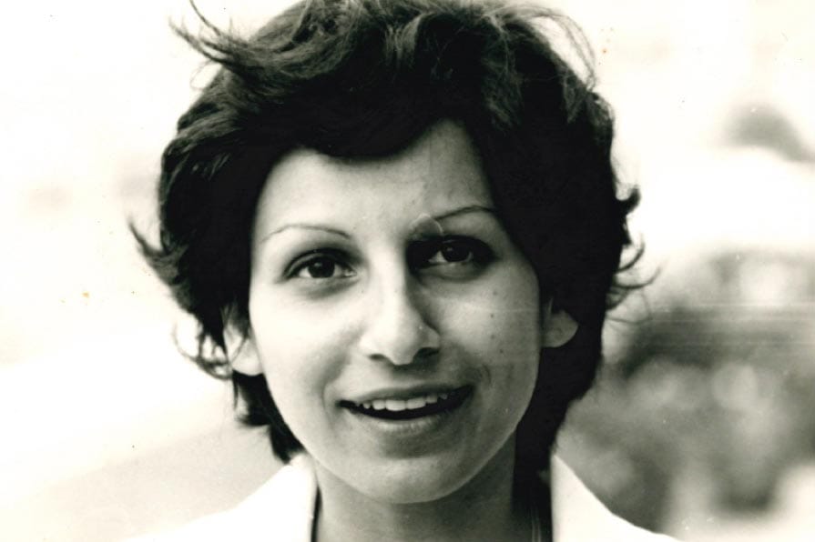 A black and white photo of Mona Fouad smiling.