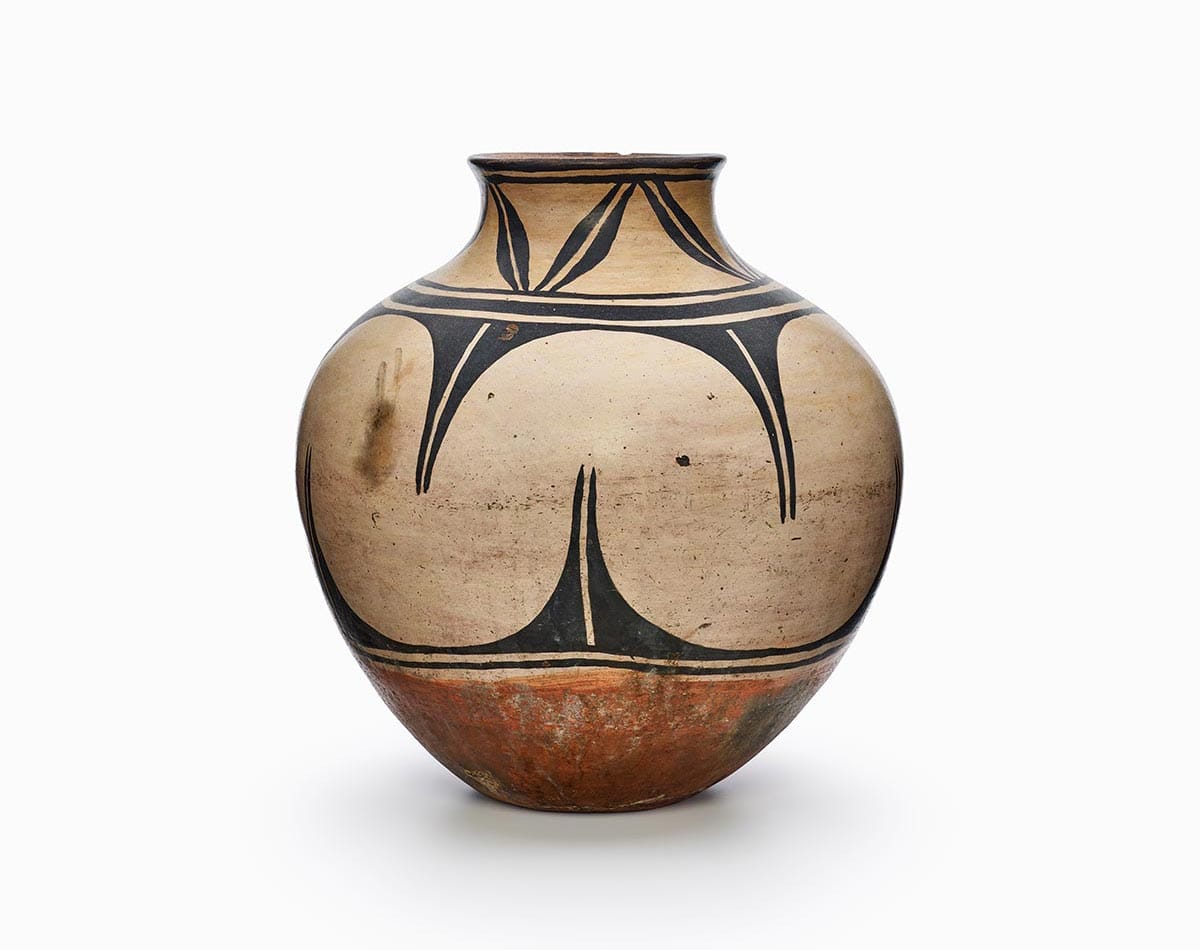 A Kewa jar painted beige and black, with two bands of design, and a rust-colored bottom.