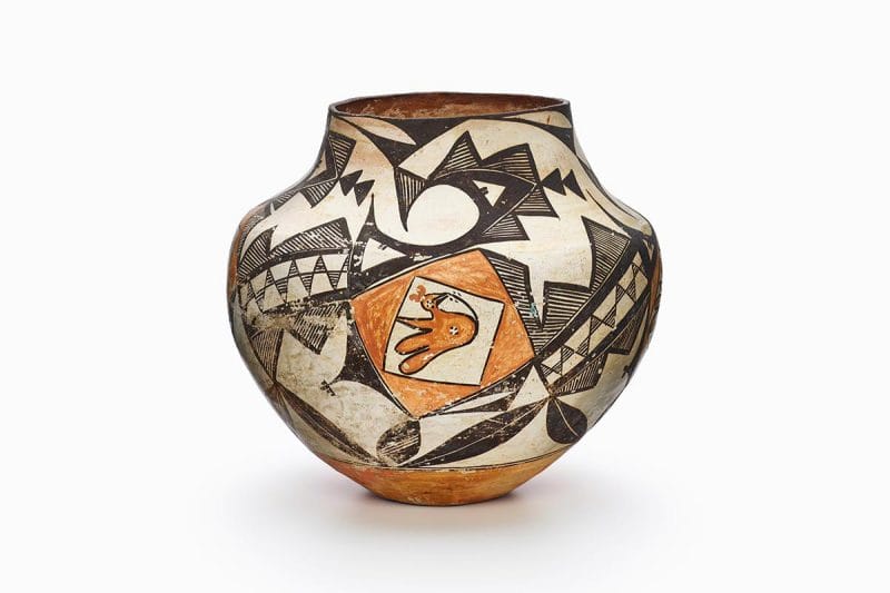 An Acoma jar decorated with a yellow bird and abstract geometric shapes and lines in black, white, and yellow.