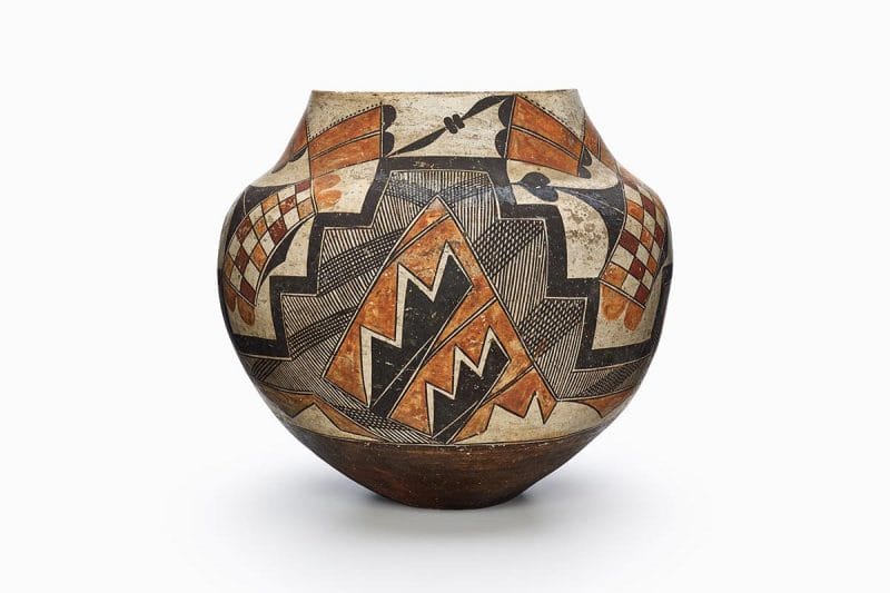 A four-color olla decorated with geometric shapes and checkered designs.