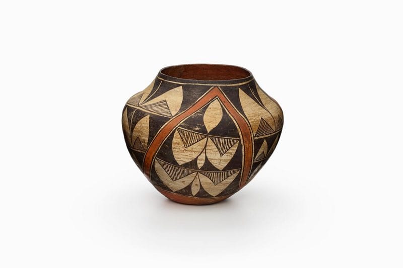 Acoma jar painted beige, rust orange, and black, with an abstract bird design.