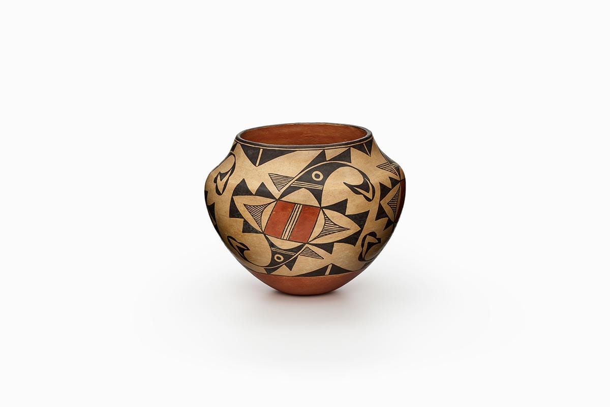 Acoma jar painted beige, rust orange, and black, with an abstract bird design.